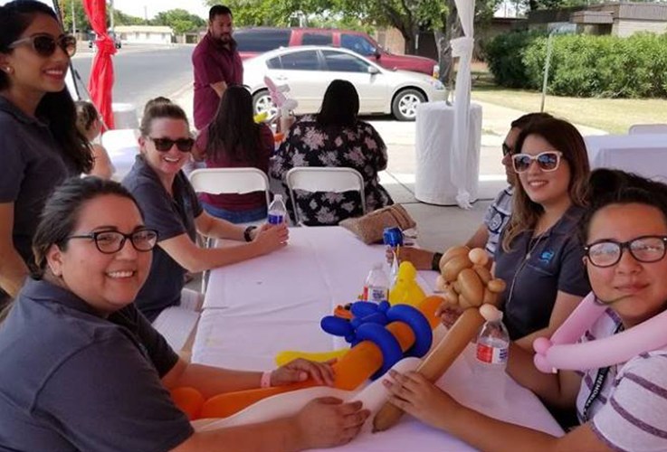 Dental team members sitting at table together during community event