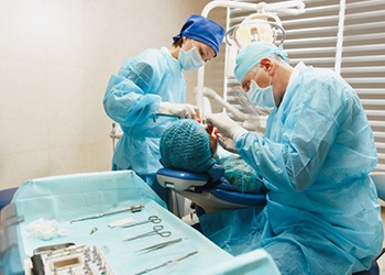 an oral surgeon performing dental implant surgery