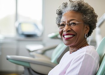 a patient smiling after receiving her dental implants