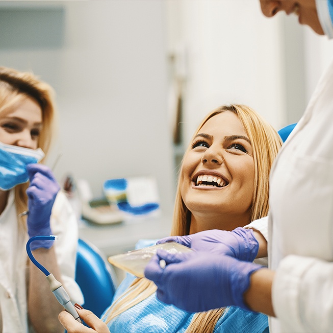 Woman in dental chair laughing during cosmetic dental bonding consultation visit