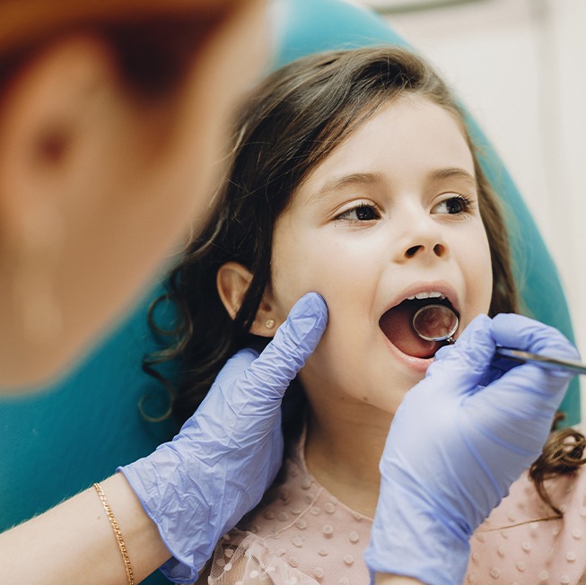 Child receiving dental checkup and teeth cleaning