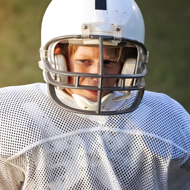 Teen boy in football gear with athletic mouthguard