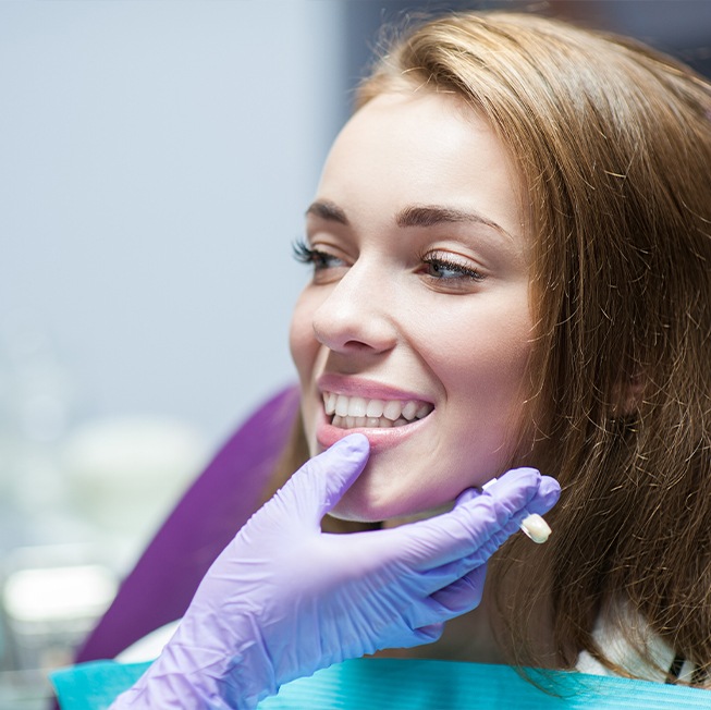 Dentist examining patient's smile after dental crown restoration