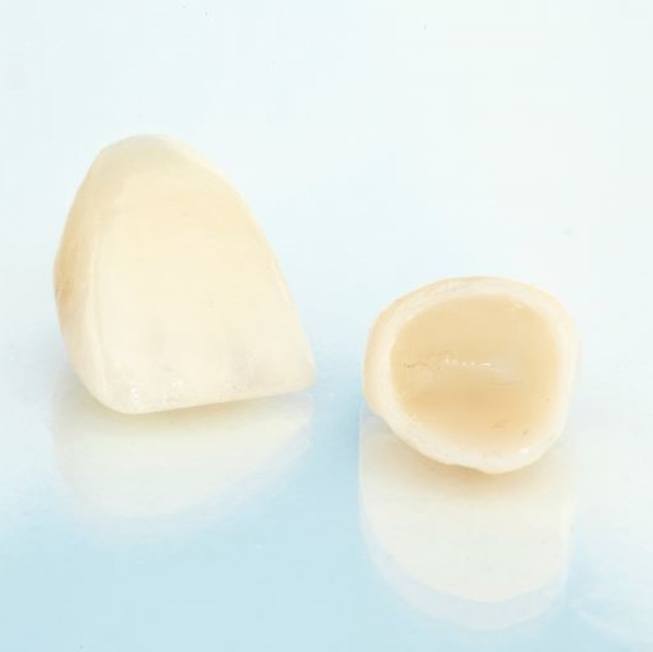 Two dental crowns against neutral background
