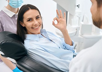 Happy dental patient making “OK” sign