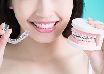 Woman holding Invisalign aligner