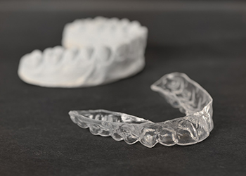 Impression and Invisalign aligner on dark background 