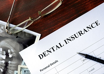 Dental insurance paperwork on brown wooden desk 