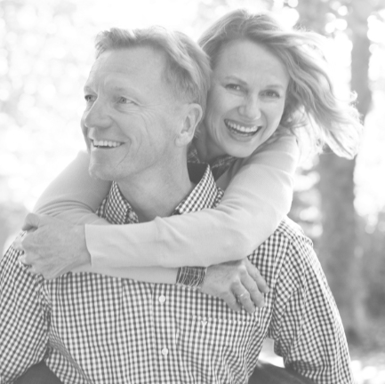 Man and woman smiling after replacing missing teeth