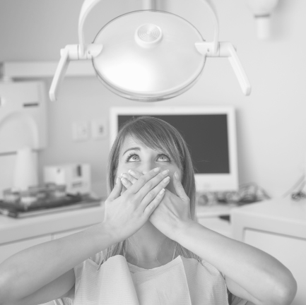 Fearful patient in need of sedation dentistry covering mouth