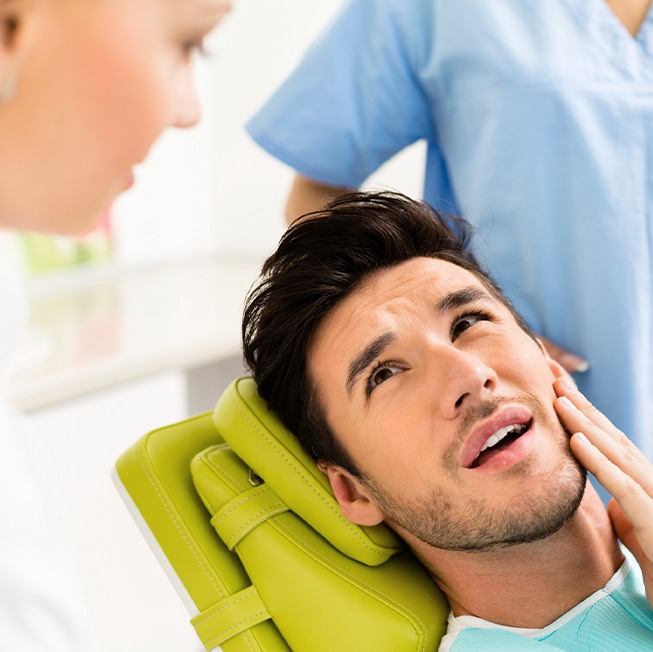 Man in need of T M J disorder treatment holding jaw