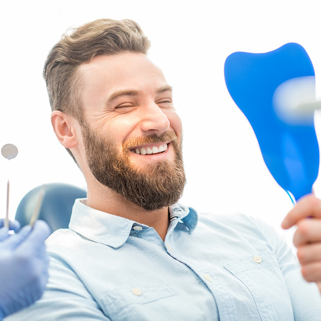 patient smiling in dental mirror 