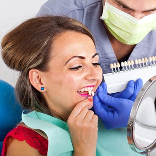 patient holding veneers up to her smile