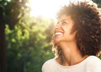 a person smiling and standing outside