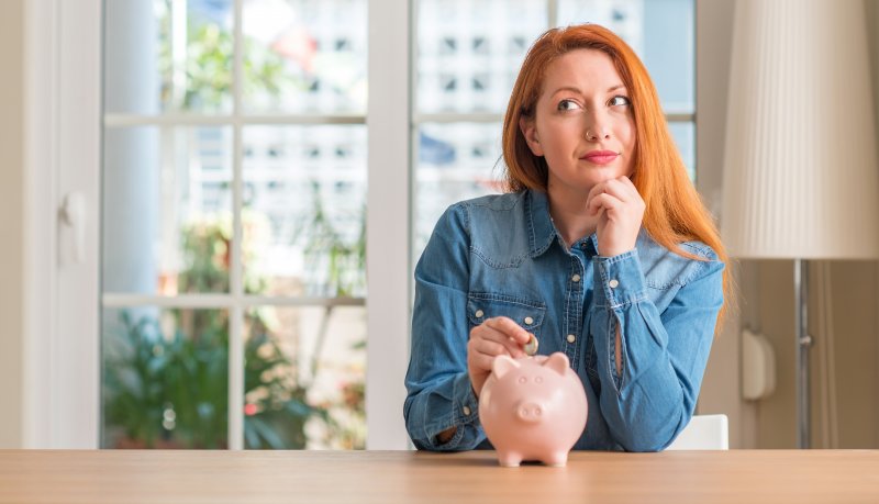 Woman putting a coin in a piggy bank